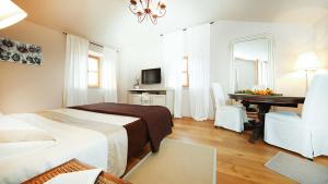 Schlafzimmer mit einem Bett, einem Schreibtisch und einem Stuhl in der Unterkunft Beautiful villa Benvenuti with private pool near Motovun in Motovun
