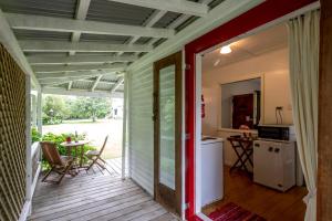 a screened in porch with a kitchen and a table at Post Office Cottage - Self catering, escape to the country in Egmont Village