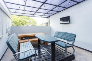 a room with two chairs and a table and a tv at RedDoorz Hostel @ Malang City Center 2 in Malang
