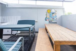 two tables and chairs in a room with a sign on the wall at RedDoorz Hostel @ Malang City Center 2 in Malang