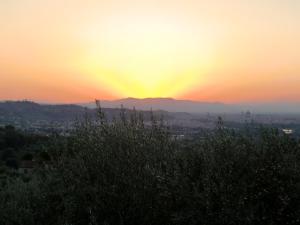 un coucher de soleil sur une ville avec une montagne en arrière-plan dans l'établissement Il Palagetto, à Bagno a Ripoli