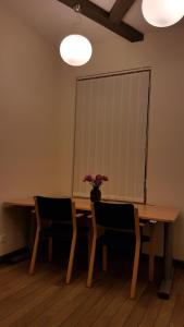 a dining room table with chairs and a vase of flowers at Gertruda apartment in Kaunas