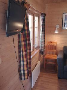 a living room with a flat screen tv in a cabin at Trollveggen Camping in Åndalsnes