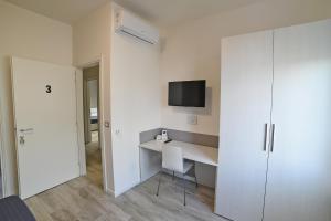 Ein weißes Zimmer mit einem Schreibtisch und einem Fernseher an der Wand in der Unterkunft Bianca Room & Breakfast in Bologna + 24 Fotos