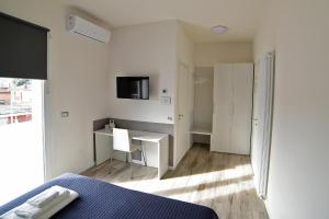 ein Schlafzimmer mit Bett, Schreibtisch und Fernseher in der Unterkunft Bianca Room & Breakfast in Bologna