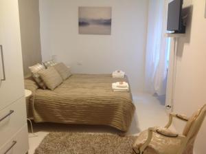 a small bedroom with a bed and a chair at Madama Suite in Turin