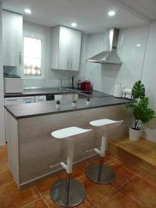 uma cozinha com um balcão e dois bancos em Apartment PALOMA em Madri