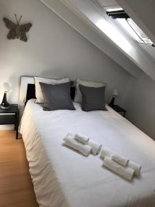 Un dormitorio con una cama blanca con toallas. en Apartment PALOMA en Madrid