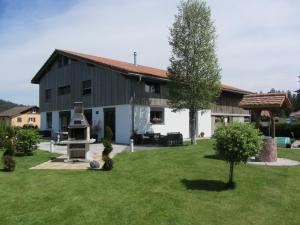 a building with a yard with a grill in front of it at Beau-Séjour in Les Breuleux