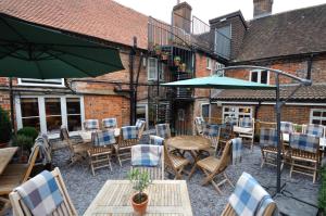 a patio with tables and chairs and an umbrella at The Marlborough in Marlborough