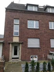 a red brick house with white windows at Einzel-Apartment Düsseldorf Oberkassel in Düsseldorf