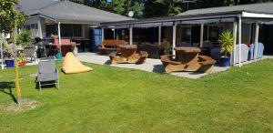 a group of chairs and tables in a yard at Happy Apple Backpackers in Motueka