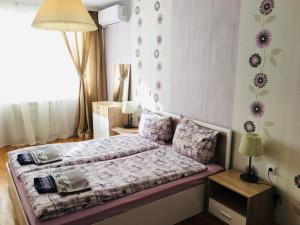 um pequeno quarto com uma cama com flores na parede em Fresh Apartment em Sófia