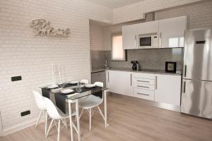 cocina con mesa, sillas y nevera en Charming & Peaceful apartment Begur with Swimming pool, en Begur