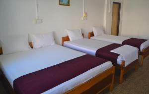 Tempat tidur dalam kamar di Gnaanams Hotel and Restaurant
