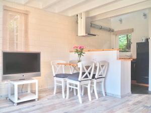 ein Esszimmer mit einem Tisch und Stühlen sowie einem TV in der Unterkunft Studio bij Zee in Ouddorp