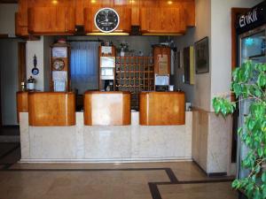 a bar in a restaurant with a clock on the wall at Kerman Hotel in Cesme