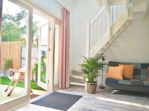 a living room with a couch and a staircase at Studio ter Duyn in Ouddorp