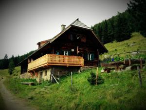 a large wooden house on a hill with a porch at Rettlhof in Sankt Peter am Kammersberg