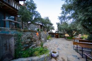 a patio with a bench and a stone wall at Kirkinca Hotel in Selcuk