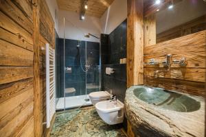 uma casa de banho com uma banheira, um WC e um lavatório. em Glinzhof Mountain Natur Resort Agriturismo em San Candido