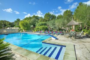 una piscina con sillas, una mesa y sombrillas en Owl Booking Villa Far - 15 Min Walk to the Beach, en Puerto Pollensa