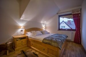 um quarto com uma cama grande e uma janela em Apartament Montagne em Zakopane