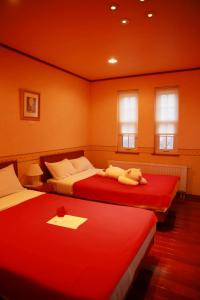 弘前市にあるアグリインホリデーのベッドルーム1室(赤いシーツを使用したベッド2台付)