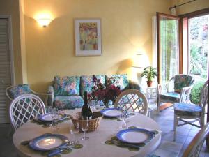 a dining room with a table and a couch at Villaggio Turistico Riviera in Cannobio
