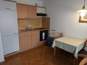 a kitchen with a table and a white refrigerator at Apparthaus Arosa in Essen
