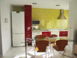 La cuisine est équipée d'une table en verre, de chaises et d'un réfrigérateur. dans l'établissement Apartamento El Ayuntamiento de Logroño, à Logroño