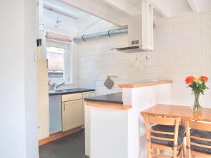 a white kitchen with a table and a counter top at Studio ter Duyn in Ouddorp