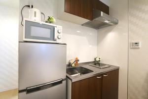 uma cozinha com um frigorífico, um lavatório e um micro-ondas em NK2 Elizabeth Garden Kurosaki em Osaka