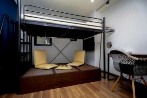 a bedroom with a bunk bed with two chairs at 043AKIHABARA in Tokyo