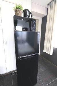 a black refrigerator with a microwave on top of it at NM71 Liz Osaka Castle in Osaka