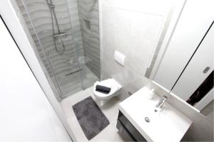 a bathroom with a shower and a sink and a toilet at Apartments Oasis in Nin