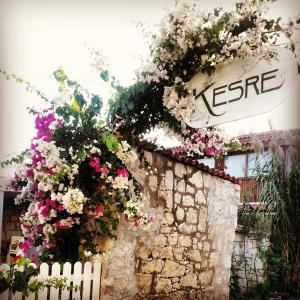 a wall with flowers and a sign on it at Kesre Hotel in Alacati