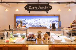 a restaurant with a display of food on a counter at Superior Hotel Edelweiss in Obertauern