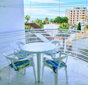 - Balcón con mesa blanca y 4 sillas en Apartamento Orquídea, en Almuñécar