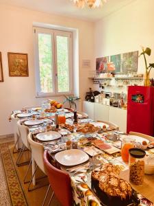 a long table with chairs and a long table with food on it at Vatica B&B Roma in Rome