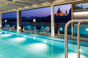 a hotel swimming pool with a view of the city at Cortile Hotel - Adults Only in Budapest