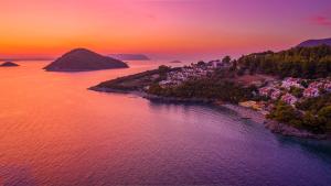 een luchtzicht op een eiland in het water bij zonsondergang bij Adrina Beach Hotel in Panormos Skopelos