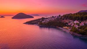 una vista aérea de una isla en el agua al atardecer en Adrina Beach Hotel, en Panormos Skopelos