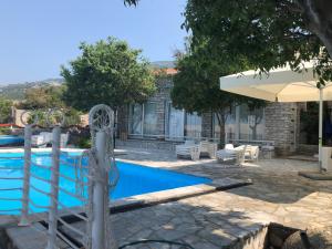 a swimming pool with an umbrella next to a building at Ferienhaus ToMa in Cesarica