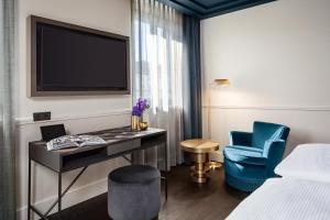 
a living room with a tv and a chair at Hotel AMO by AMANO Friedrichstraße in Berlin
