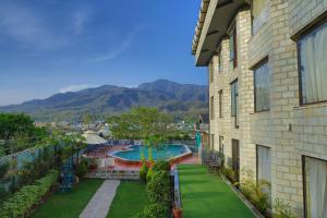 un balcón de una casa con piscina en Hotel Natraj Rishikesh en Rishīkesh