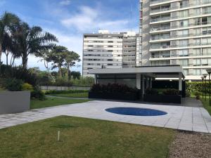 un grand bâtiment à côté d'une cour avec un bâtiment dans l'établissement Edificio Jardines del Country Piso 19, à Punta del Este