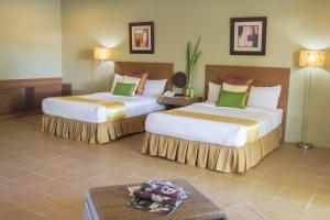 a hotel room with two beds and a table at Almont Inland Resort in Butuan +27 photos