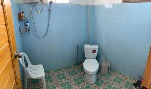 a blue bathroom with a toilet and a shower at Sano Houes in Sukhothai