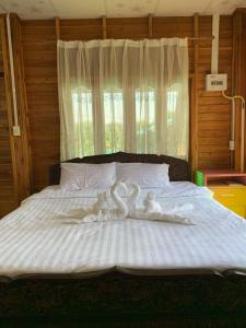 dwa łabędzie siedzące na łóżku w sypialni w obiekcie Sano Houes w mieście Sukhothai